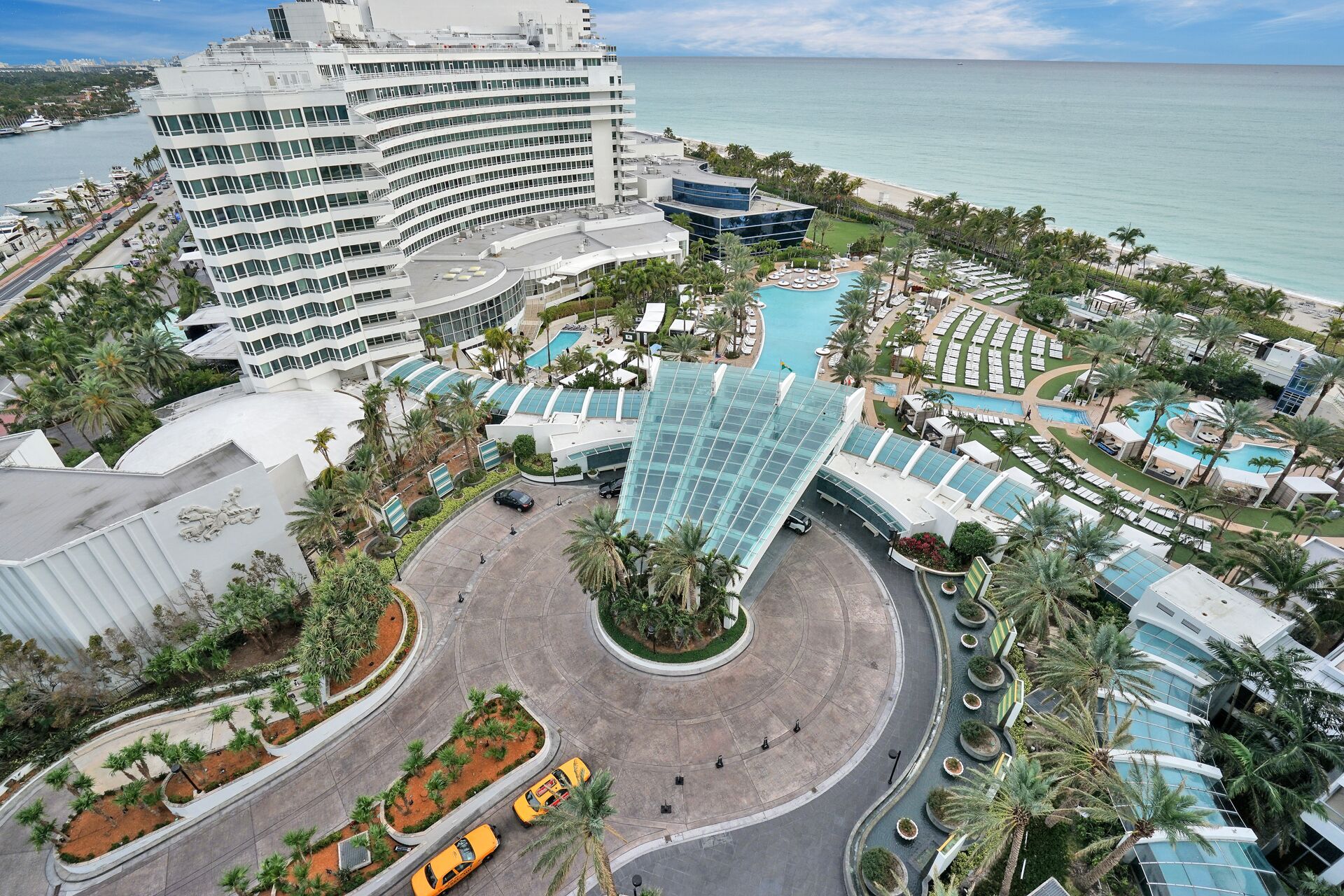 Un complexe hôtelier doté d’une piscine centrale, de plusieurs bâtiments et offrant une vue sur la plage.
