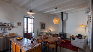 A spacious living area with a wooden dining table, a sofa, and a fireplace.