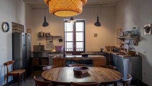 A modern kitchen with a central island, wooden chairs, and a round dining table.