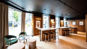 A modern interior with a bar area, seating, and artwork on the walls.