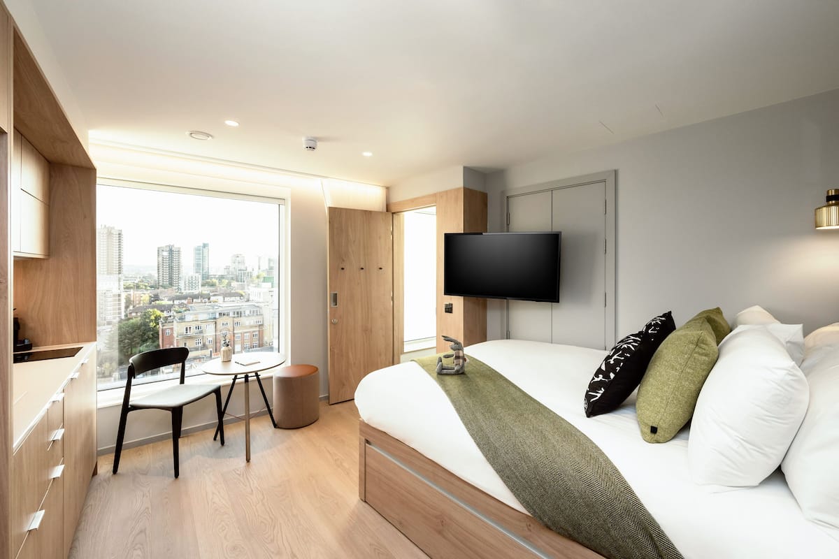 Une chambre d’hôtel moderne équipée d’un grand lit, d’une télévision, d’un bureau et d’une chaise.