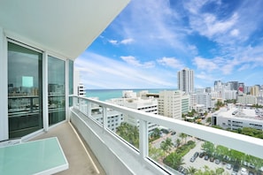A balcony with a view of a cityscape and the ocean.