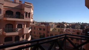 A pink building with balconies and a clear blue sky.