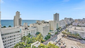 A coastal cityscape with modern buildings, a clear sky, and a view of the ocean. - Ocean & Bay Junior Suite in the Fontainebleau (Miami Beach)