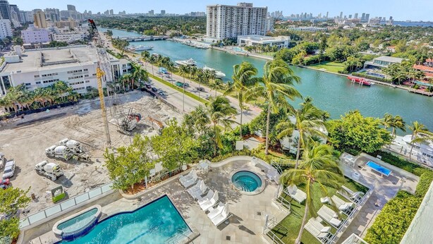 A high-rise hotel with a pool area, a marina, and a view of the city skyline. - Ocean & Bay Junior Suite in the Fontainebleau (Miami Beach)