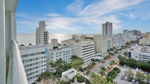 A high-rise hotel with multiple floors, a parking area, and a view of the ocean. - Ocean & Bay Junior Suite in the Fontainebleau (Miami Beach)