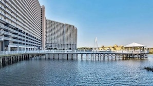 Un hotel sul lungomare con un lungo molo che si protende nell'acqua, numerosi balconi e un edificio grande con tetto piano.