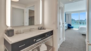 Un baño de hotel moderno con un espejo grande, un lavabo y tocador.