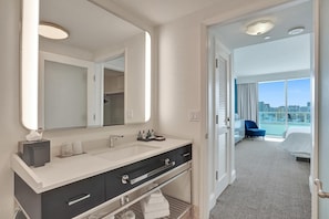 Een moderne hotelbadkamer met een grote spiegel, een wastafel en een opbergmeubel.