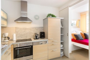 A compact kitchen with a stove, oven, and modern cabinetry.