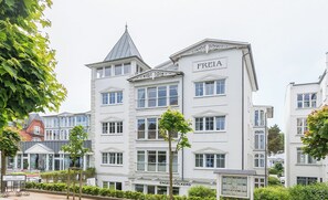 A multi-story building with the name "FREIA" on the facade, featuring a classic architectural style with a prominent tower and multiple windows. - Sea view in the 1st row Villa Freia Apartment Meeresglück with beach chair (Binz)