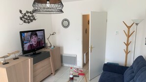 Ein Wohnzimmer mit Fernseher, Sofa und Couchtisch.