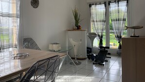 Ein Essbereich mit Tisch, Stühlen, einem Toaster und einer Pflanze auf einem Regal.