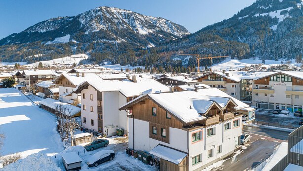 A snow-covered mountain town with traditional wooden buildings and a modern Salvenpark hotel. - Apartment 1 minute from the ski lift (Brixen im Thale)