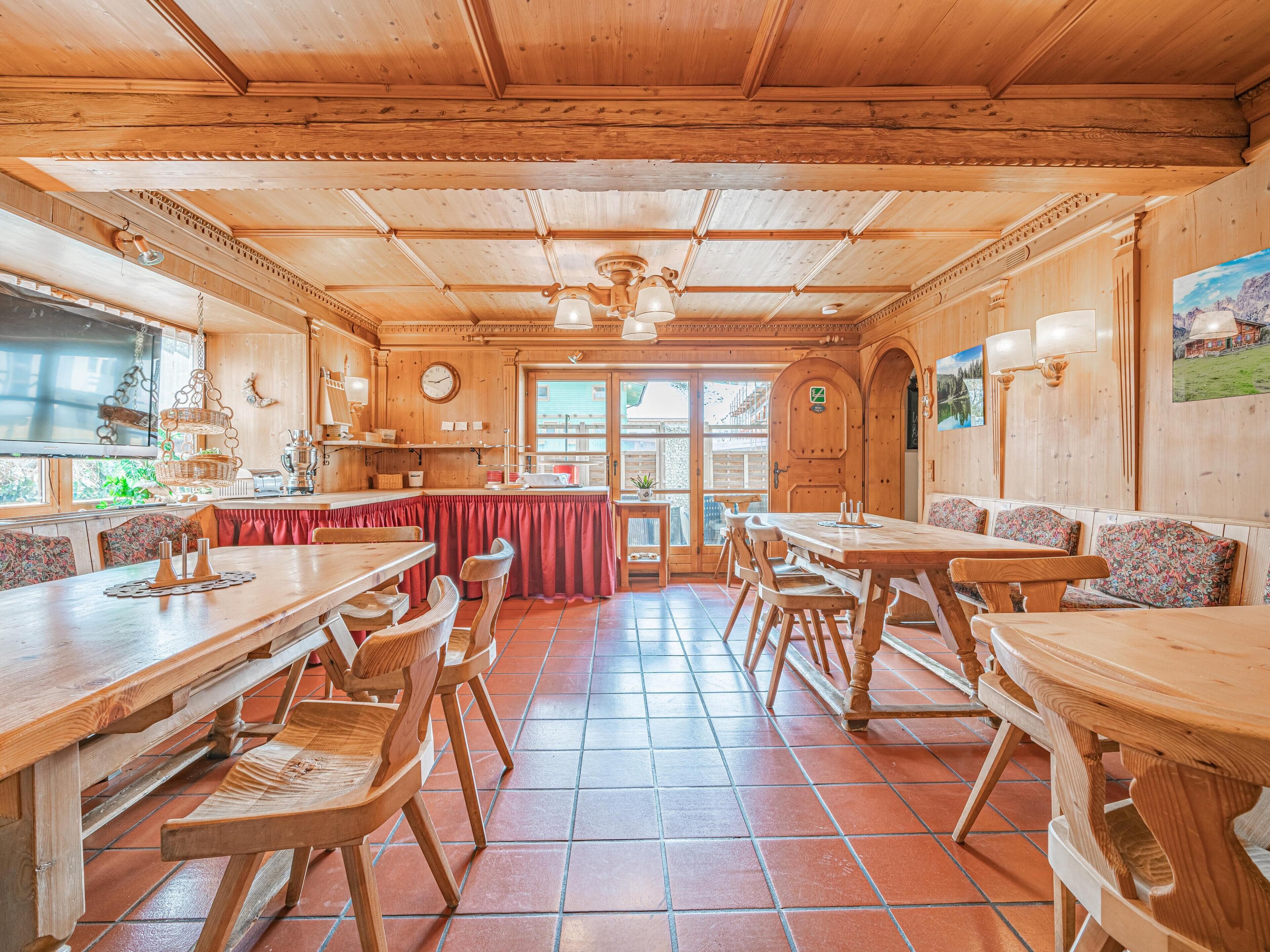 Un interior de madera con comedor, bancos y una encimera de cocina.