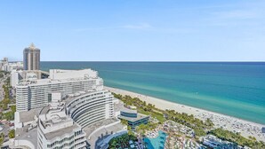 Un hôtel situé sur la côte, avec vue sur la plage, composé de plusieurs bâtiments et doté d’un espace piscine.