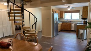 A modern kitchen with a built-in refrigerator, wooden cabinets, and a stainless steel dishwasher. - Two story home with Las Moras Creek views (Brackettville)