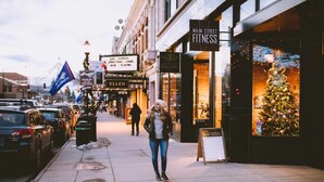 A pedestrian street lined with shops, including a fitness center and a gallery.