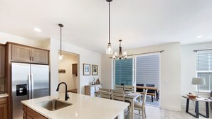 A modern kitchen with a central island, stainless steel appliances, and wooden cabinetry.