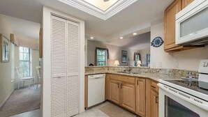 A kitchen with wooden cabinets, a dishwasher, a microwave, and an oven.