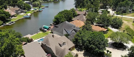 An aerial view of a residential area with houses, a river, and boats.