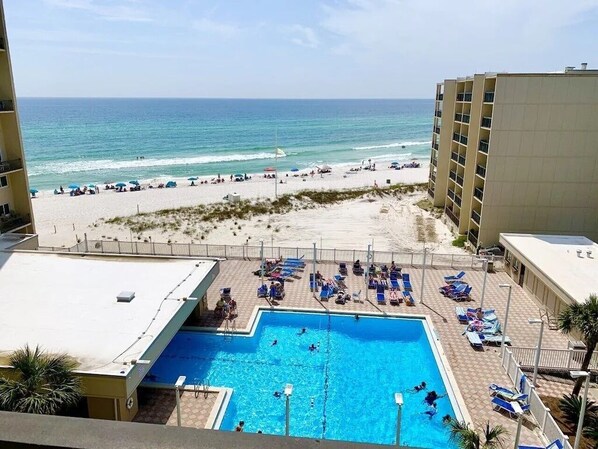 Relax by the rooftop pool overlooking the beach and ocean, with lounge chairs and umbrellas at your disposal.
