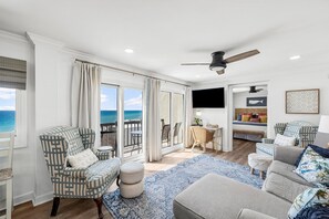 Relax in this ocean-view living area with a ceiling fan, flat-screen TV, and comfortable seating options.