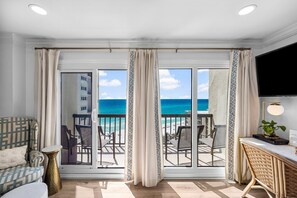 Enjoy ocean views from the balcony, featuring a sofa, table, and flat-screen TV.