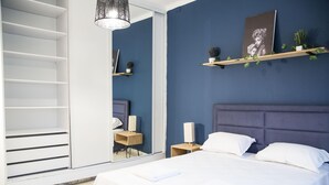 A bedroom with a bed, bedside tables, a mirror, and a shelf with decorative items. - Apt Moderne Face au Parc et au c ur de la Marsa (La Marsa)