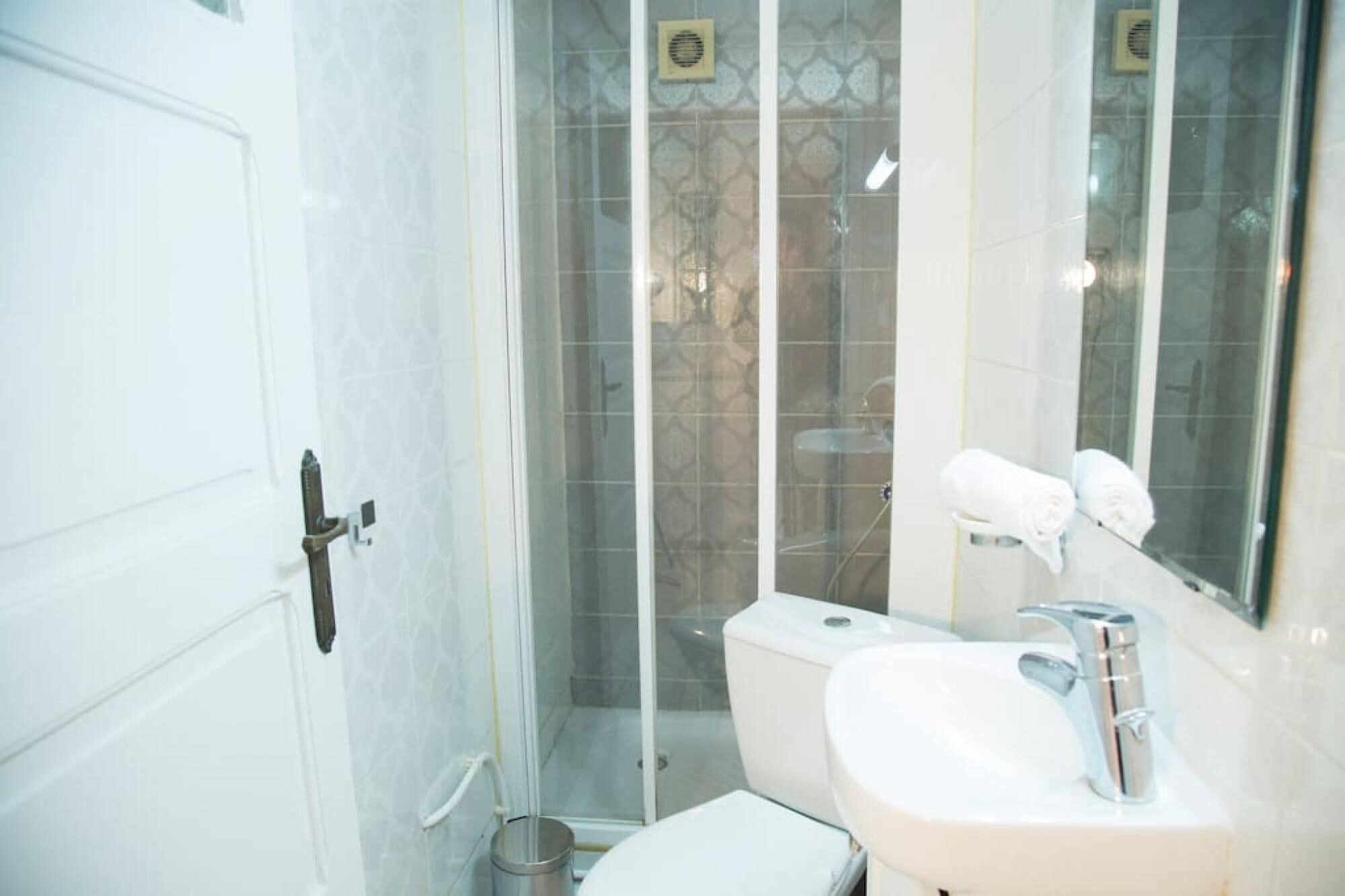 Une salle de bain avec des toilettes, un lavabo et une douche.