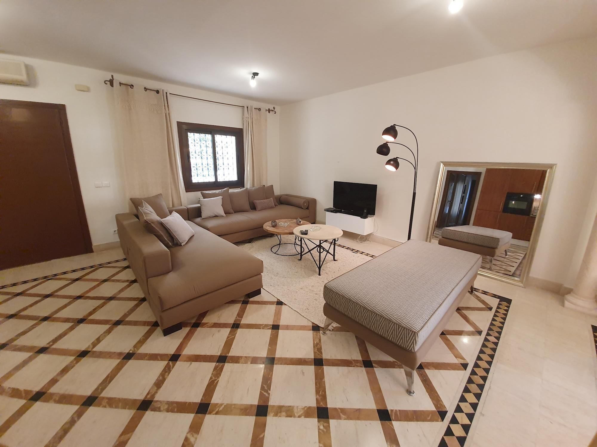 Una sala moderna con un sofá, una mesa de centro, un televisor y una cama.