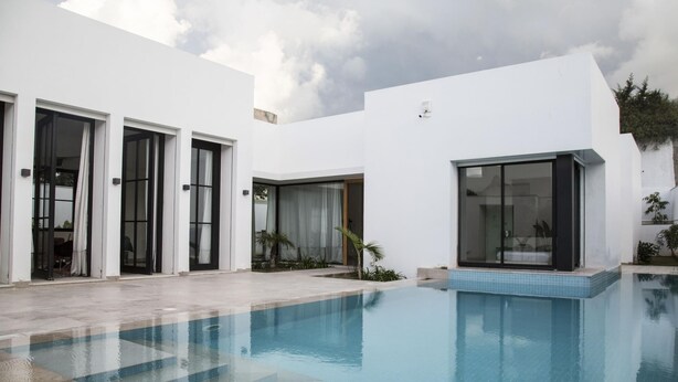 A modern house with a swimming pool, large windows, and a clean, white exterior. - Les Verrières De Gammarth: Villa moderne +Piscine (La Marsa)