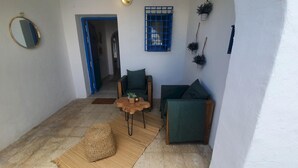 Un espacio de estar acogedor con un sofá, una pequeña mesa de madera y una alfombra tejida.