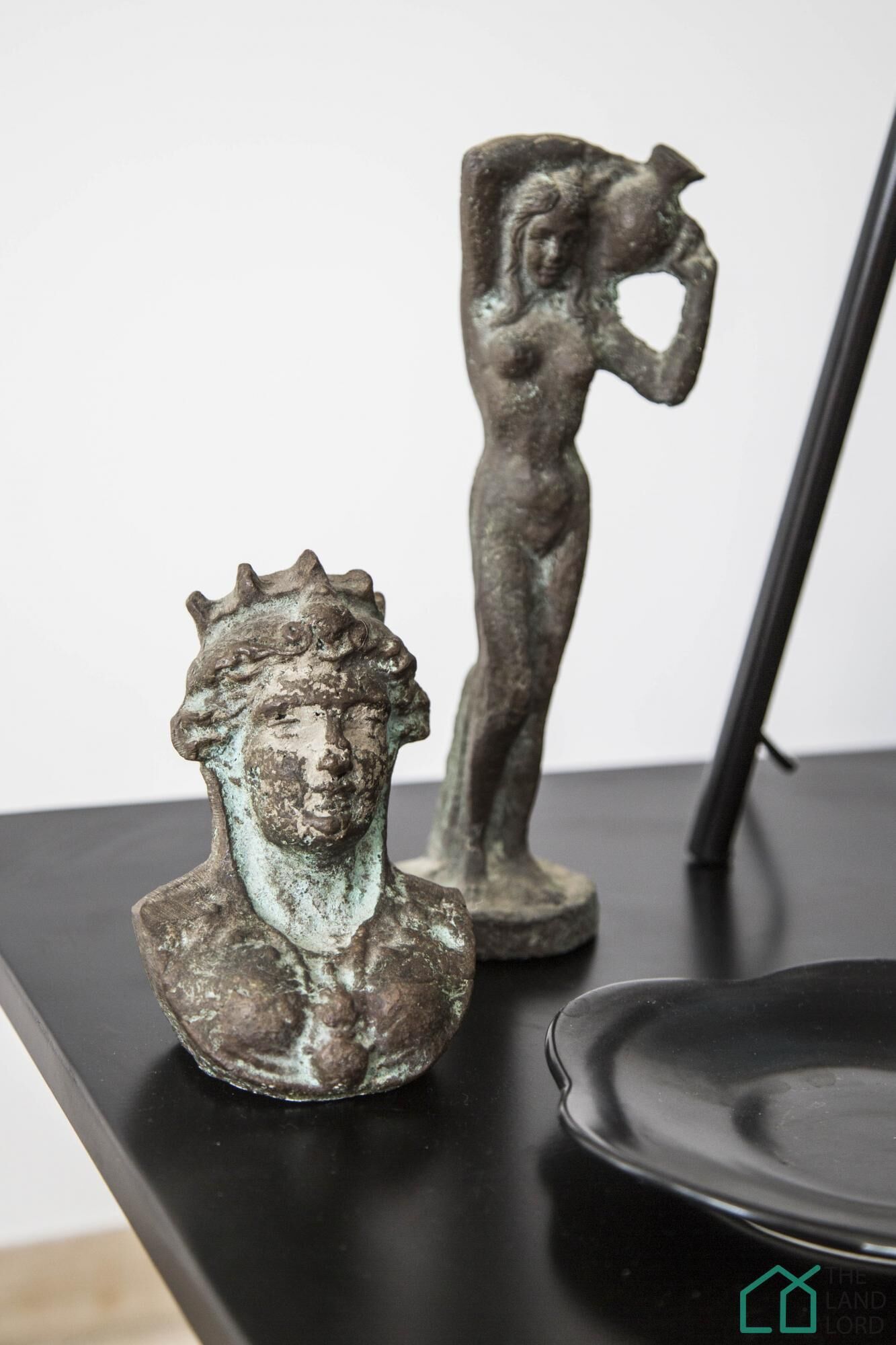 Two bronze sculptures on a black surface.