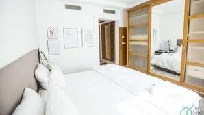 Ein Hotelzimmer mit Bett, Nachttisch, Spiegel und Kleiderschrank.
