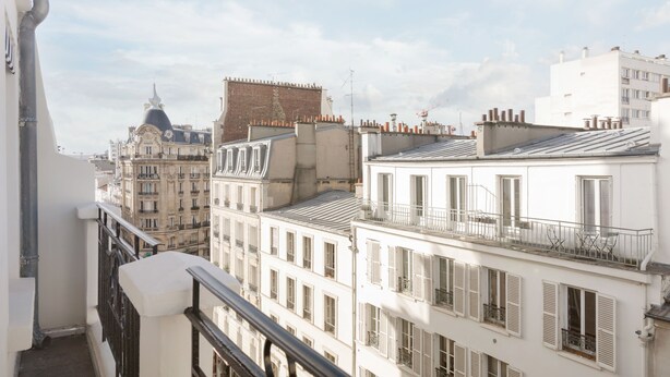 Vista de un paisaje urbano con varios edificios, incluyendo un edificio destacado con cúpula y uno blanco con balcones.