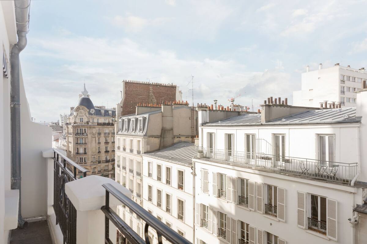 A view of a cityscape with multiple buildings, including a prominent building with a dome and a white building with balconies.