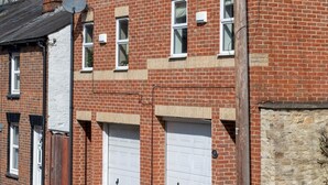 A two-story brick building with a garage and satellite dishes. - A Very British Place to Stay - 3 Bedrooms Central (Oxford)