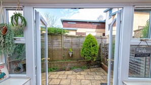 A garden with a wooden fence, a small tree, and hanging plants. - A Very British Place to Stay - 3 Bedrooms Central (Oxford)