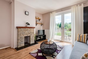 A living room with a fireplace, a TV, and a sofa.