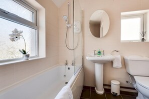 A bathroom with a bathtub, a sink, and a toilet. - The Oxford Abode - 3-bedroom House - Large Garden (Oxford)