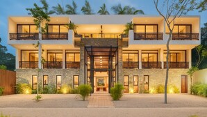 A modern two-story house with a central entrance, large windows, and a well-lit exterior. - Irie Tulum  (Tulum)