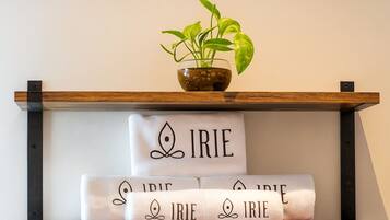 Een plank met een potplant en handdoeken met de tekst 'IRIE' er op.