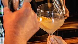 Un bar con una persona sirviendo una bebida en un vaso.