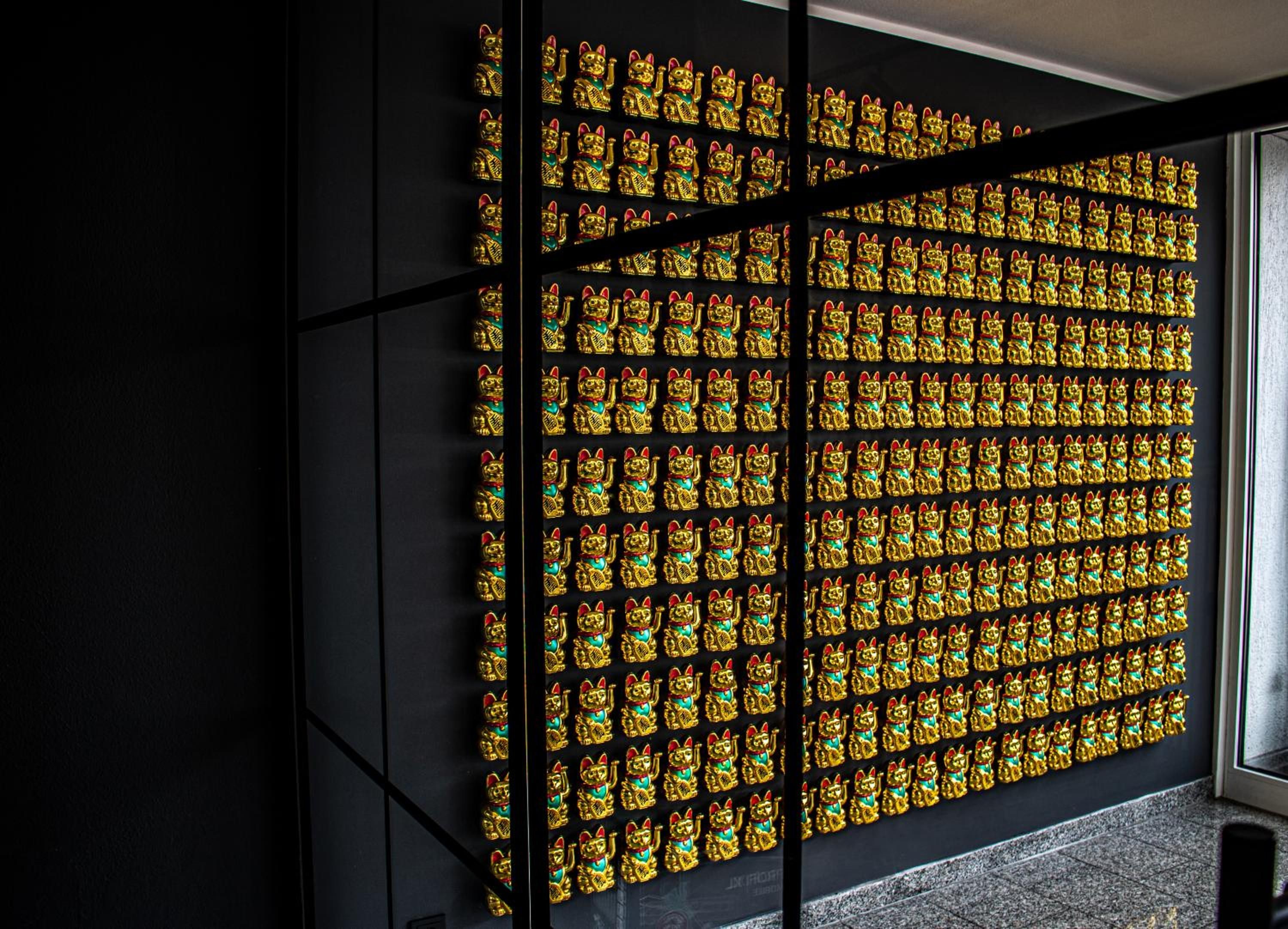 Una pared con una cuadrícula de estatuas doradas.