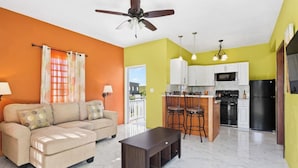Un apartamento moderno con sala de estar, kitchenette y comedor.