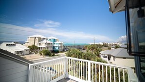 A residential area with a balcony, houses, and a clear sky. - Peach On The Beach 4 BR Beachfront Getaway, Rooftop Patio (Panama City Beach)