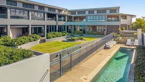 Un hôtel moderne doté d’une piscine, d’un espace extérieur aménagé et d’un jardin bien entretenu.