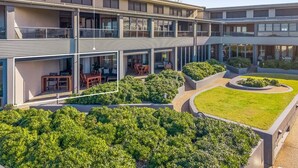 Un bâtiment moderne à plusieurs niveaux, doté d’espaces de détente en plein air et de jardins aménagés.