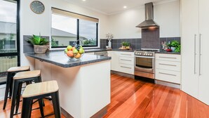 Una cocina moderna con una isla central, electrodomésticos de acero inoxidable y un amplio ventanal.